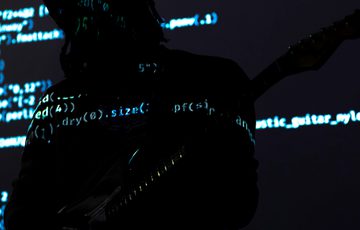 Computer code projected over a silhouette of a person.