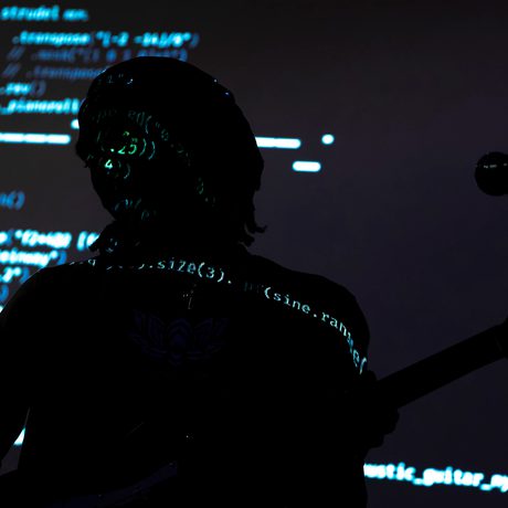 Computer code projected over a silhouette of a person.