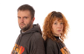 Two people back to back wearing We Will Rock You T-shirts.