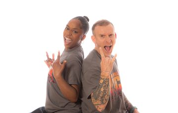 Two people with hands sign of the Horns (Rock On) posing back to back.