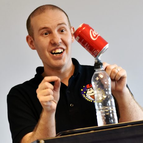 A person balancing a can of pop on top of a water bottle.