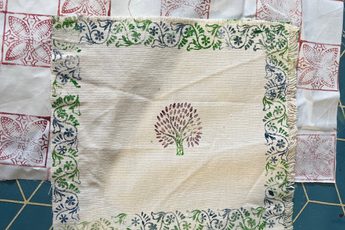Printed decorated fabric squares laid out.