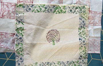 Printed decorated fabric squares laid out.