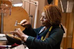 A lady at work with tools in her hands.