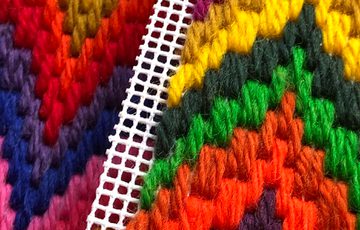 Close up of a colourful tapestry pattern.