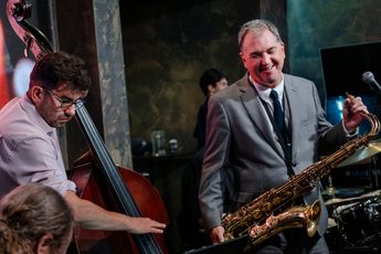 Two people with musical instruments performing.