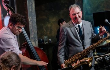 Two people with musical instruments performing.