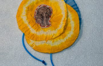A circular craft of item in yellow and blue.