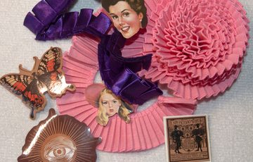 A craft item made if ribbons and photos in pink and purple.