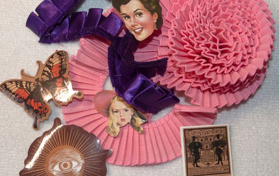 A craft item made if ribbons and photos in pink and purple.