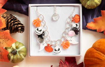 A necklace designed with colourful Halloween themed items in a box surrounded by decorative leaves and pumpkins.