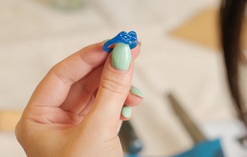 A hand holding a ring mould.
