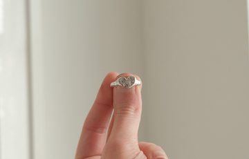 A hand holding a ring.