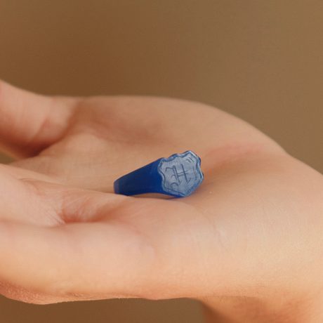 A person hand holding a blue mould of a ring.