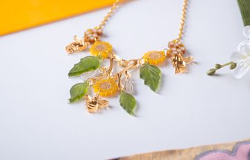 A necklace designed with leaves, sunflowers and bees