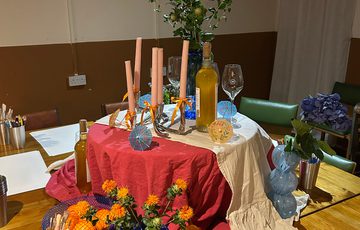A table decorated with vases, flowers and painting supplies.