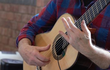 Close up of hands playing a guitar.