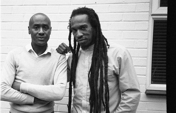 Black and white photo of Pogus Caesar and Benjamin Zephaniah standing looking at camera.