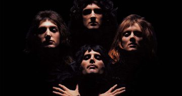 Picture of heads of three men at the top and one below with hands crossed against his chest against a black background