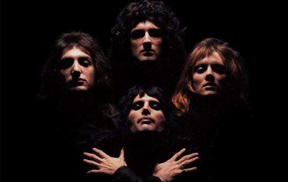 Picture of heads of three men at the top and one below with hands crossed against his chest against a black background