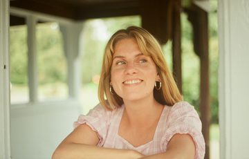 A lady smiling while looking away from the camera.