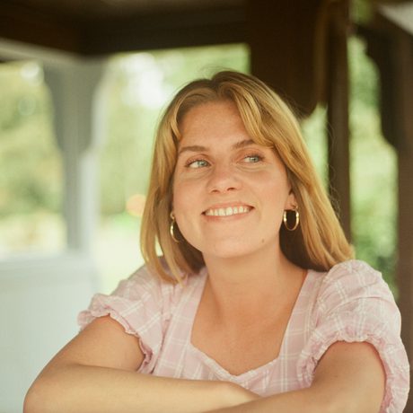 A lady smiling while looking away from the camera.