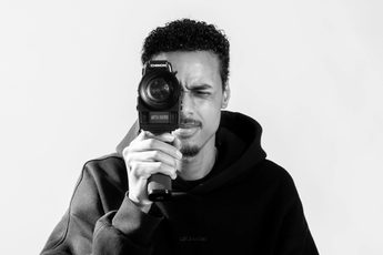 Black and white photo of a man holding a camera.