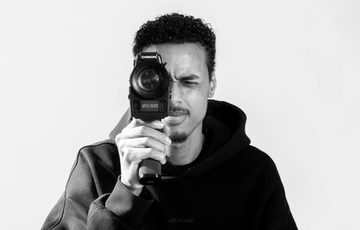 Black and white photo of a man holding a camera.
