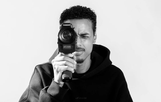 Black and white photo of a man holding a camera.