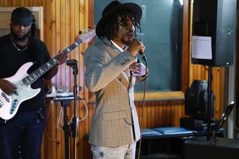 A person standing in a room with a microphone.