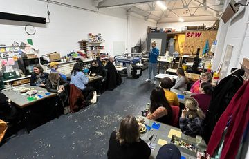 A workshop space with people sitting at tables.