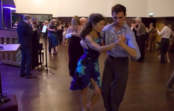 A room of people dancing in pairs.