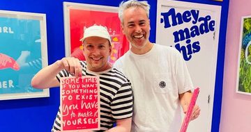 Two people one is holding a screen print.