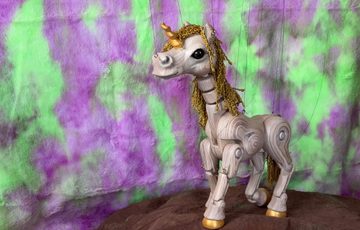 A unicorn puppet against a coloured background.