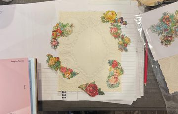 A picture of a grey table with cards with pictures of flowers being made