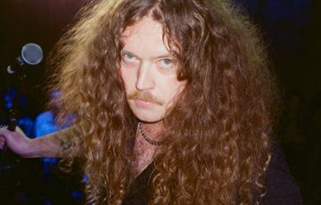 Headshot of Bradley Taylor holding a microphone behind him.