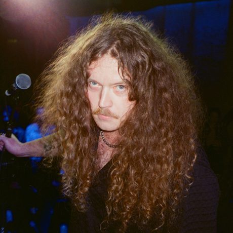 Headshot of Bradley Taylor holding a microphone behind him.