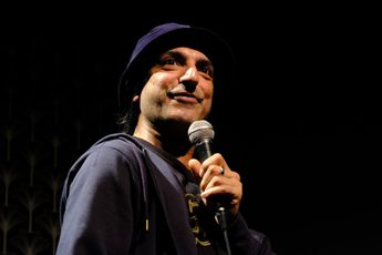 Dharmander Singh performing and holding a microphone.