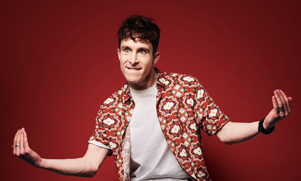 Larry Dean crouching on a stool.