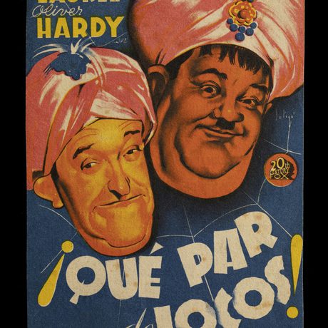 Poster with a drawing of two men's faces with Laurel and Hardy printed at the top left in yellow, and Que Par de Lotos! in white below the faces