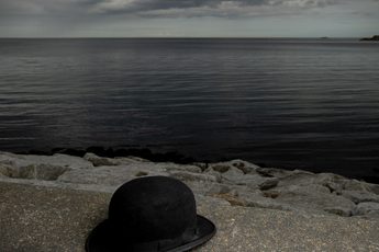posetr of bowler hat on a sea wall with sea and clouds. Title text in white "The Last Dance of the Cookoos"