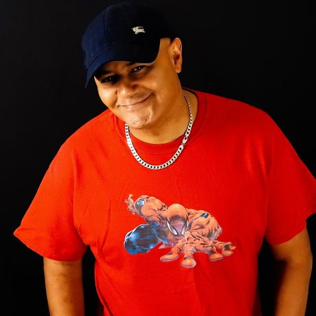 Nik Coppin headshot, smiling and wearing a black cap and red t-shirt.