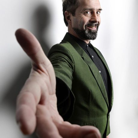 Phil Nichol with his hand held out to the camera.