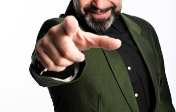 Phil Nichol pointing towards the camera.