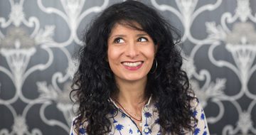 Shappi Khorsandi head shot looking up to the left.