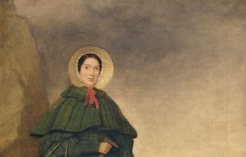 A painting of a lady standing outside, she wears a green dress with bonnet and holds a hammer or tool and carries a basket. She is standing next to a large rock and the sea behind her. A dog is curled up at her feet.