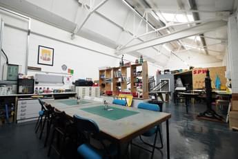 A print works studio space with table chairs in the centre.