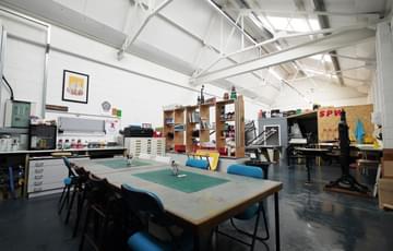 A print works studio space with table chairs in the centre.