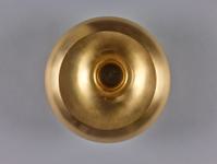 Circular shaped golden coloured vessel viewed from above. It has a round inlet in the middle.