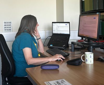 A volunteer working on a computer at desk.